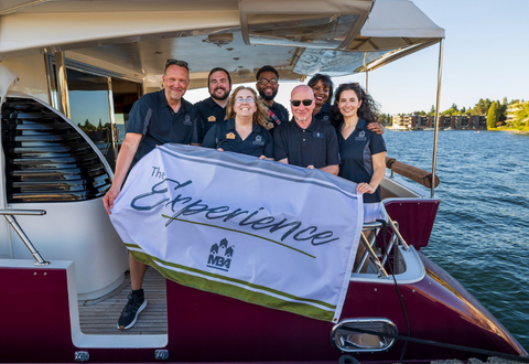 Team holding white flag with the word Experience spelled out on a boat.
