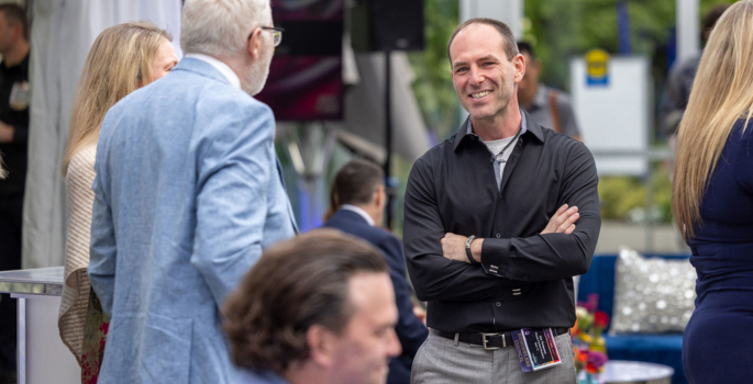 Three people talking at an event.